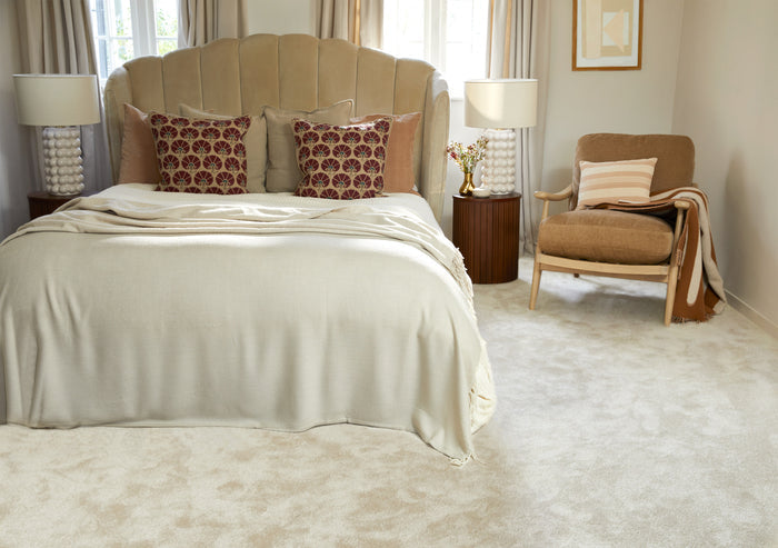 Neatly made bed with decorative pillows in a bedroom setting.